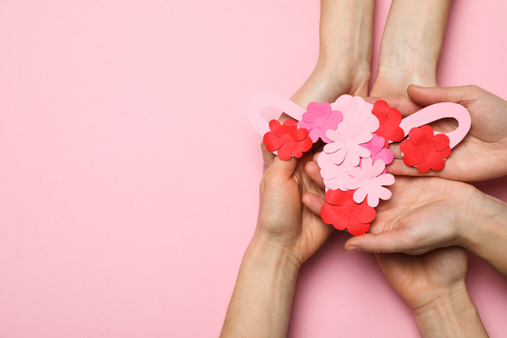 mani che tengono utero di carta con fiori colorati